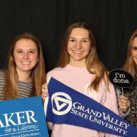 three friends using props for a picture at GradFest